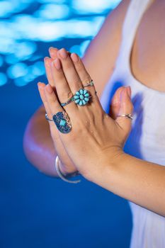 Woman holding namaste in clean water. Palms with gypsy boho rings. Meditation, praying, gratitude, purity background. . High quality photo