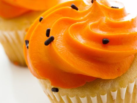 Halloween orange and black cupcakes on white background.