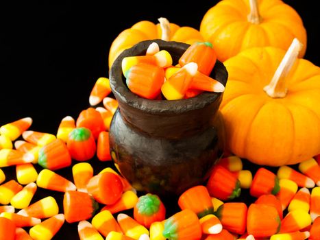 Halloween candies spilled on black background.