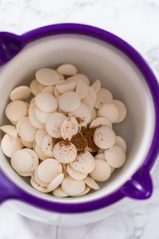 Melting white chocolate chips in a candy melting pot to make a chocolate gingerbread man.
