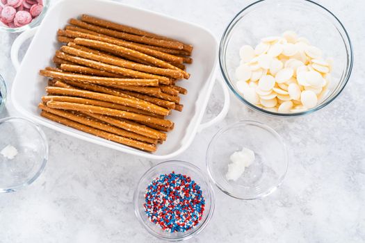 Ingredients in glass mixing bowls to prepare chocolate dipped pretzel rods for the July 4th celebration.