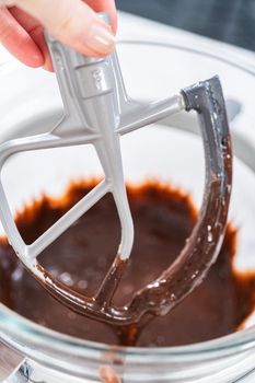 Whipping chocolate ganache with an electric kitchen mixer.