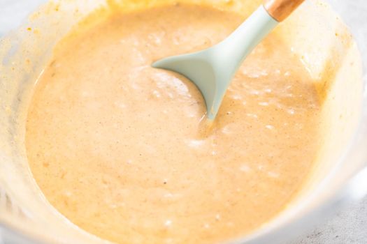 Pumpkin pancakes batter in a glass mixing bowl.