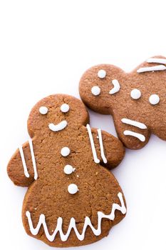 Homemade gingerbread cookies decorated with white icing on white background.