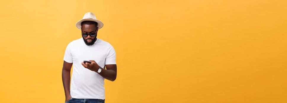 Cheerful African American man in white shirt using mobile phone application. happy dark skinned hipster guy read news from social network in mobile phone