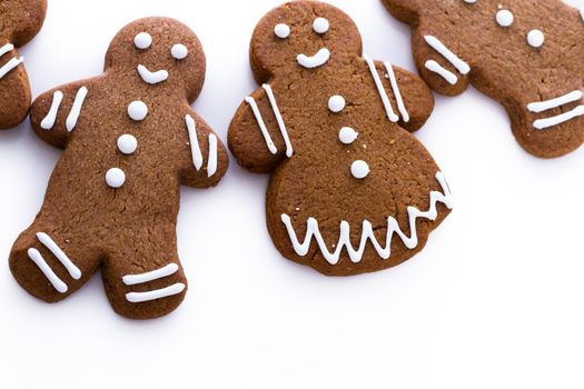 Homemade gingerbread cookies decorated with white icing on white background.