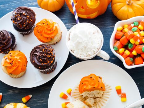 Eating Halloween cupcakes with orange and black icing.