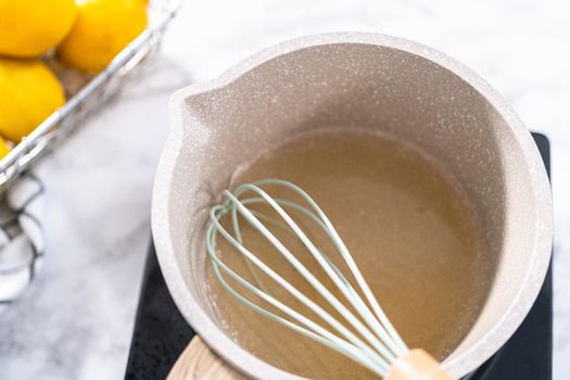 Cooking cake syrup for cake in a saucepan.