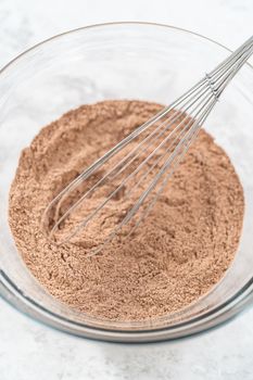 Mixing ingredients in a glass mixing bowl to bake s'mores cupcakes.