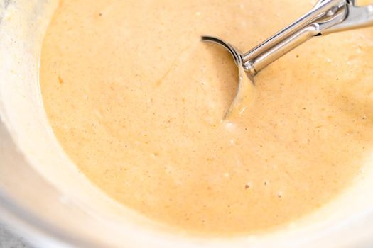 Pumpkin pancakes batter in a glass mixing bowl.