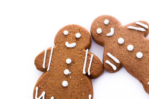 Homemade gingerbread cookies decorated with white icing on white background.
