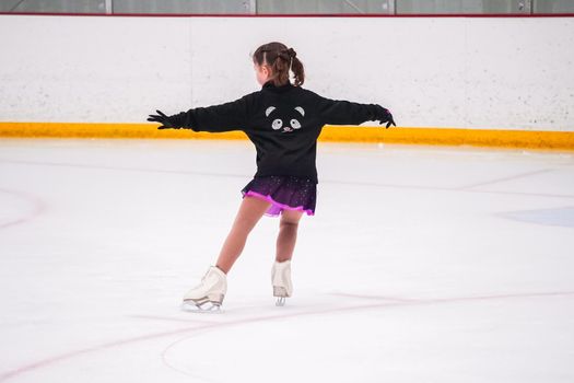 Little girl practicing before her figure skating competition at the indoor ice rink.