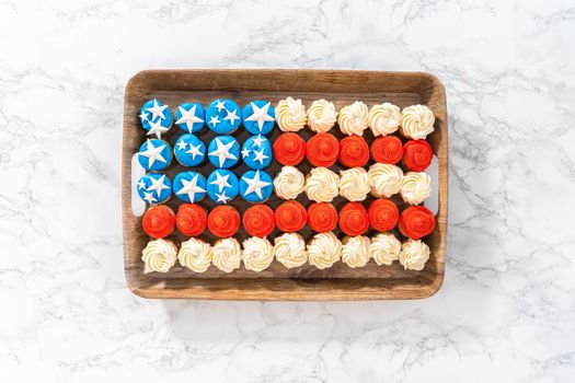 Flat lay. Arranging mini vanilla cupcakes in the shape of the American flag.