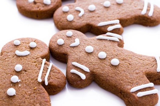 Homemade gingerbread cookies decorated with white icing on white background.