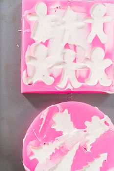 Filling silicone mold with white melted chocolate to make a chocolate gingerbread man.