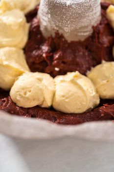 Filling metal bundt cake pan with cake butter to bake red velvet bundt cake with cream cheese glaze