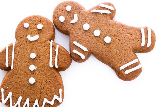 Homemade gingerbread cookies decorated with white icing on white background.