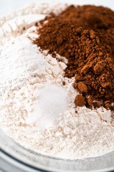 Mixing ingredients in a large glass mixing bowl to bake red velvet bundt cake with cream cheese glaze.