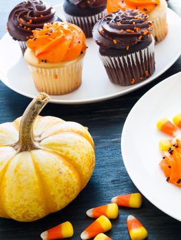 Eating Halloween cupcakes with orange and black icing.