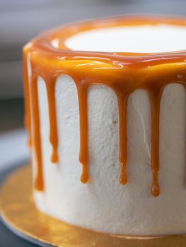 professional baker decorating a chocolate and cream cake with salty caramel