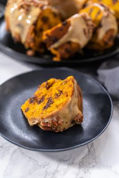 Slice of homemade chocolate pumpkin bundt cake with toffee glaze on a plate.