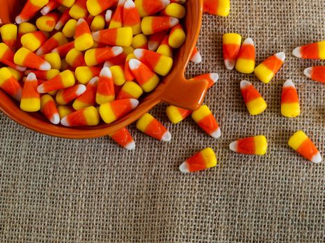 Traditional Halloween candies candy corn in orange bowl.