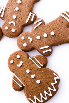 Homemade gingerbread cookies decorated with white icing on white background.