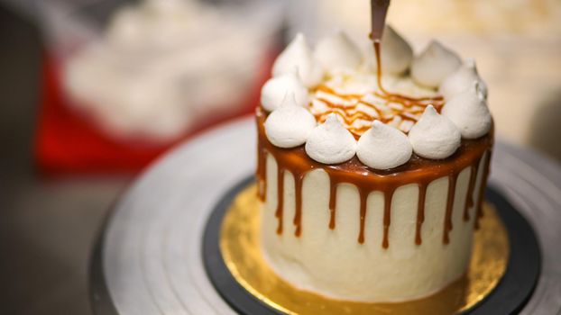 chef decorating the top of a frosted buttercream cake