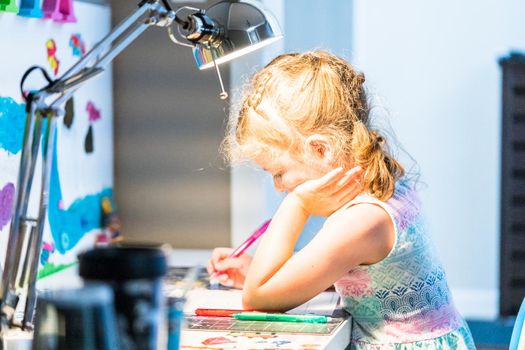 Little girl studying at home during the e-learning school.