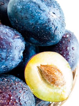 Fresh plums in basket on white background.