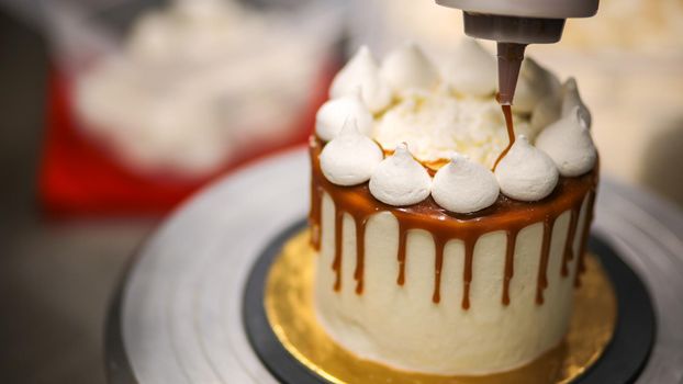 chef decorating the top of a frosted buttercream cake