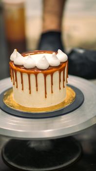 chef decorating the top of a frosted buttercream cake
