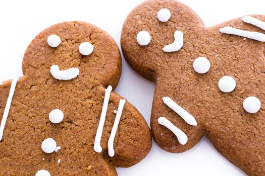 Homemade gingerbread cookies decorated with white icing on white background.
