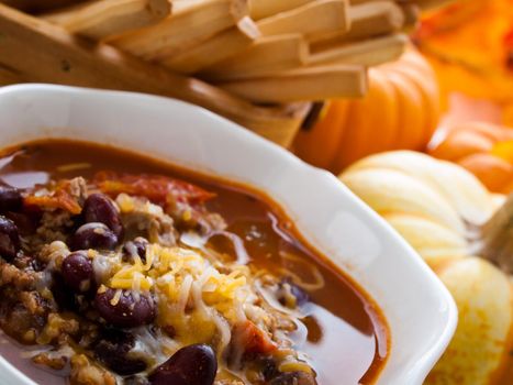 Homemade chili with ground turkey meat in white bowl.