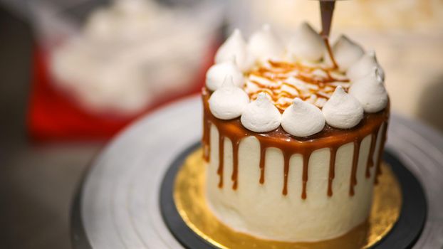 chef decorating the top of a frosted buttercream cake