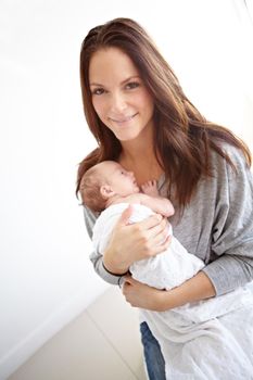 Shes my bundle of joy. Portrait of a young mother holding her newborn daughter at home