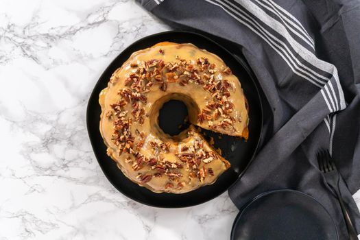 Flat lay. Slicing homemade chocolate pumpkin bundt cake with toffee glaze.