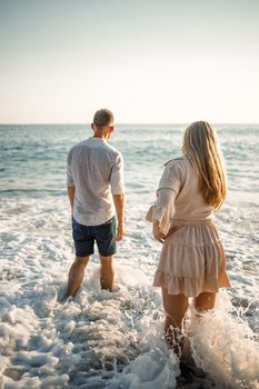 Happy couple by the sea. Honeymoon lovers. Man and woman on the island. Beautiful couple having fun on the seashore. Happy couple on vacation. Man and woman by the sea.