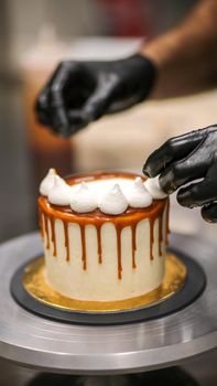 chef decorating the top of a frosted buttercream cake