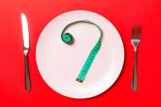 Fork and plate with measuring tape on color background. Diet concept