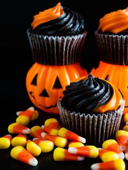 Halloween cupcakes decorated with black and orange swirled icing.