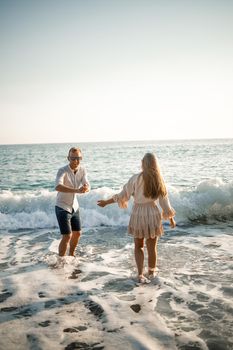 Happy couple by the sea. Honeymoon lovers. Man and woman on the island. Beautiful couple having fun on the seashore. Happy couple on vacation. Man and woman by the sea.