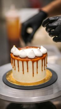 chef decorating the top of a frosted buttercream cake