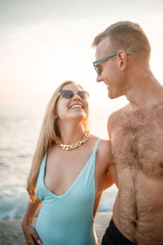 Romantic young couple in love walking together at sunset along the Mediterranean beach. Summer vacation in a warm country. Happy married couple on vacation in Turkey. Selective focus