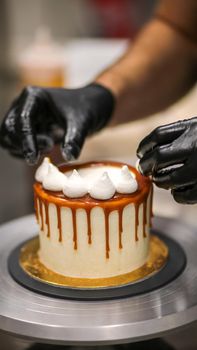 chef decorating the top of a frosted buttercream cake