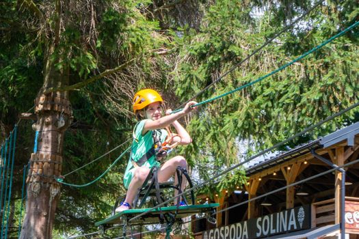adventure climbing high wire park - people on course in mountain helmet and safety equipment. High quality photo