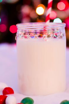 Glass of milk in a jar with a red straw.