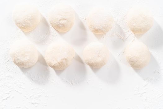 Rolling bread dough with a french rolling pin to make homemade flatbread.