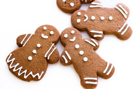 Homemade gingerbread cookies decorated with white icing on white background.