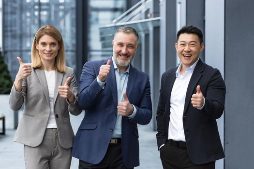 Cheerful dream team, senior and experienced IT professionals in business suits smiling and happy holding thumb up and looking at camera, diverse group of project managers outside office building.